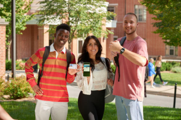 a group of three students showing their id+ card and mobile id+ cards on their devices